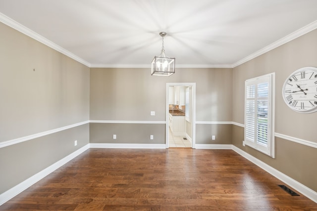 unfurnished room featuring dark hardwood / wood-style flooring, crown molding, and an inviting chandelier