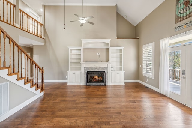 unfurnished living room featuring a fireplace, hardwood / wood-style floors, high vaulted ceiling, and ceiling fan