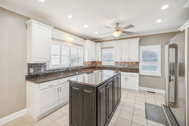 kitchen with tasteful backsplash, a kitchen island, high end fridge, and sink