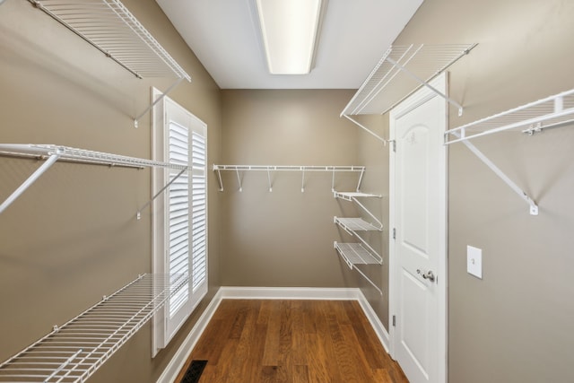 spacious closet with dark hardwood / wood-style floors