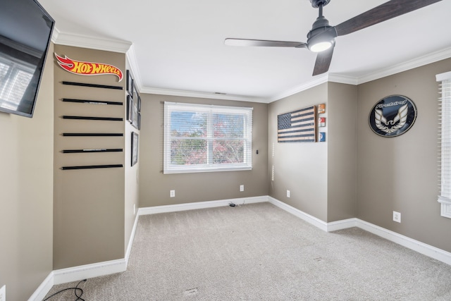 carpeted empty room with ceiling fan and crown molding