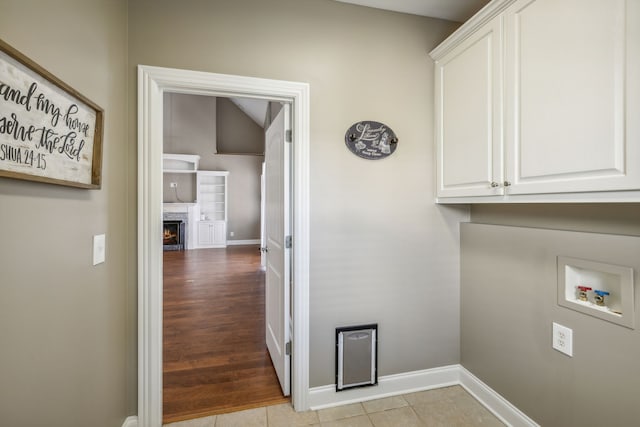 laundry area featuring light hardwood / wood-style flooring, cabinets, and washer hookup