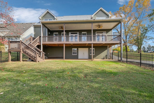 rear view of property with ceiling fan, a yard, and a wooden deck