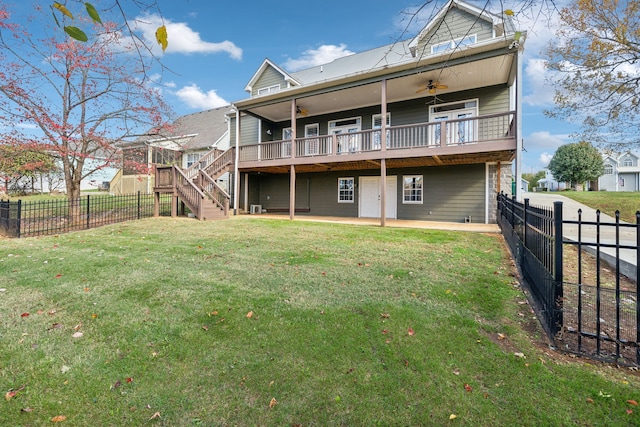 back of property with a deck, a yard, and a patio