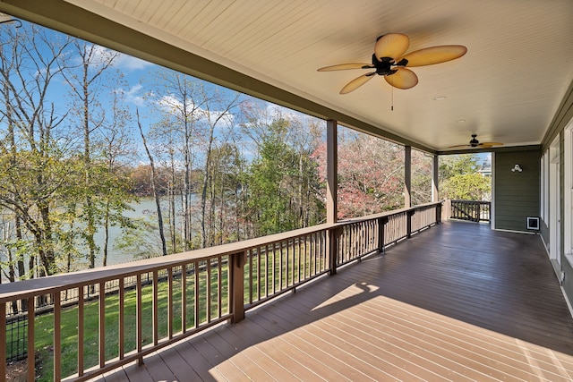 wooden terrace featuring ceiling fan, a yard, and a water view