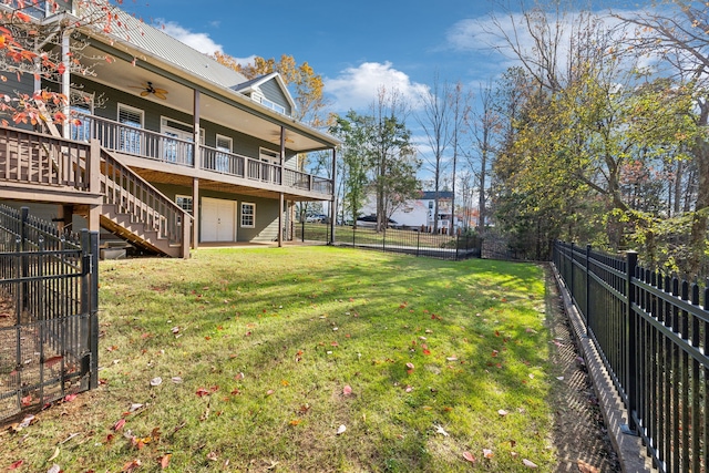 view of yard with a deck and ceiling fan