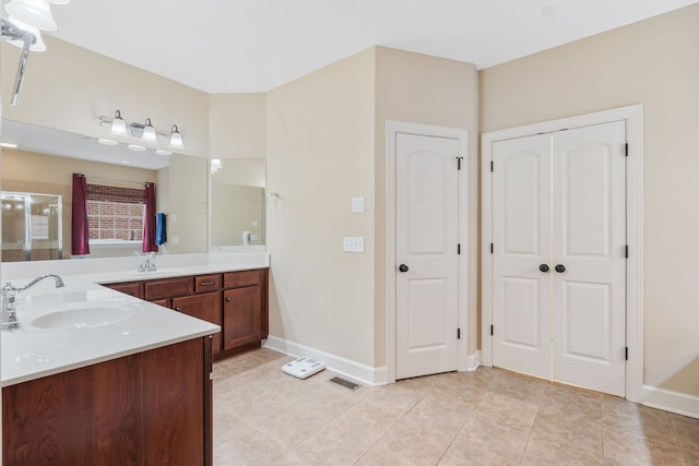 bathroom featuring tile patterned flooring, vanity, and walk in shower