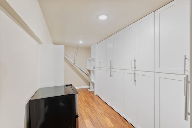 corridor with light hardwood / wood-style floors