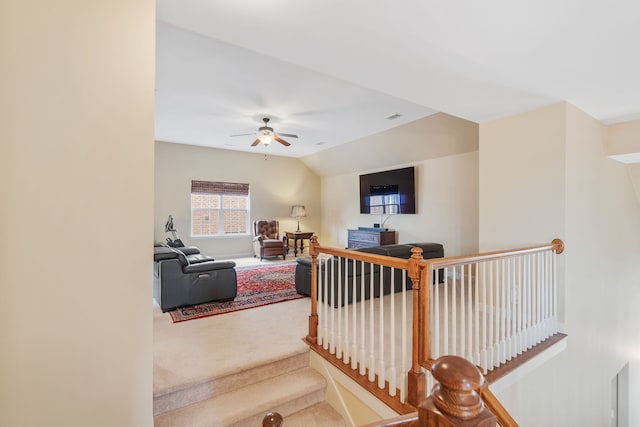 living room with ceiling fan, carpet floors, and vaulted ceiling