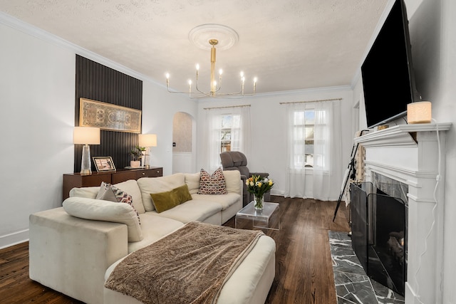 living room featuring a chandelier, a textured ceiling, dark hardwood / wood-style flooring, and ornamental molding