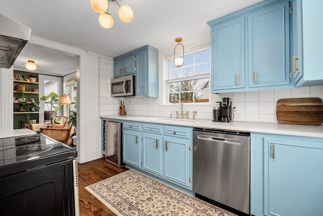 kitchen with tasteful backsplash, wine cooler, blue cabinets, and appliances with stainless steel finishes