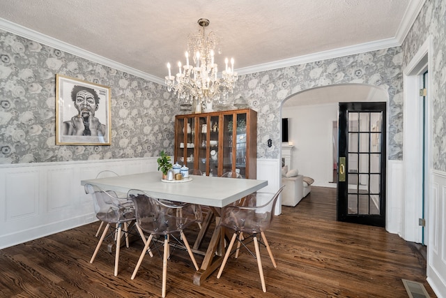 dining space with a textured ceiling, dark hardwood / wood-style floors, and ornamental molding