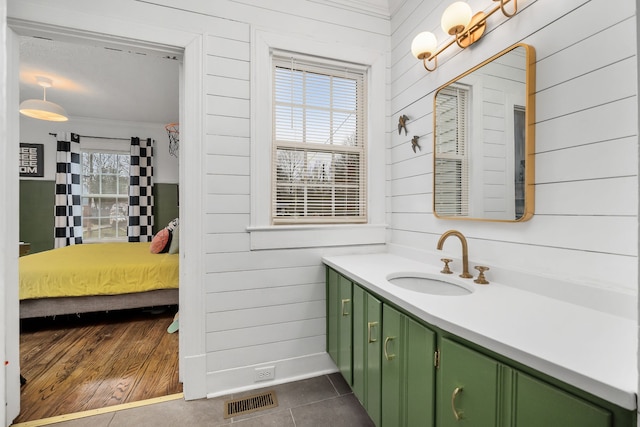 bathroom with tile patterned flooring, plenty of natural light, and wooden walls