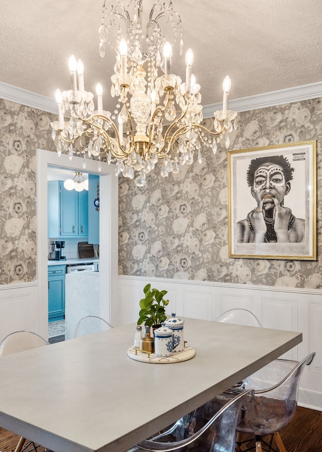 dining room featuring hardwood / wood-style flooring, crown molding, a textured ceiling, and an inviting chandelier