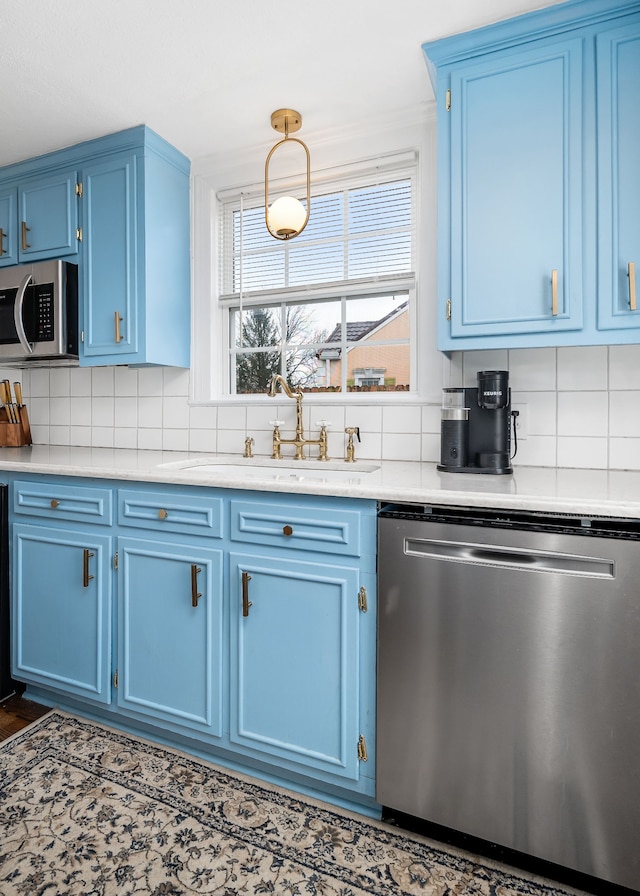 kitchen with backsplash, hanging light fixtures, stainless steel appliances, and blue cabinets