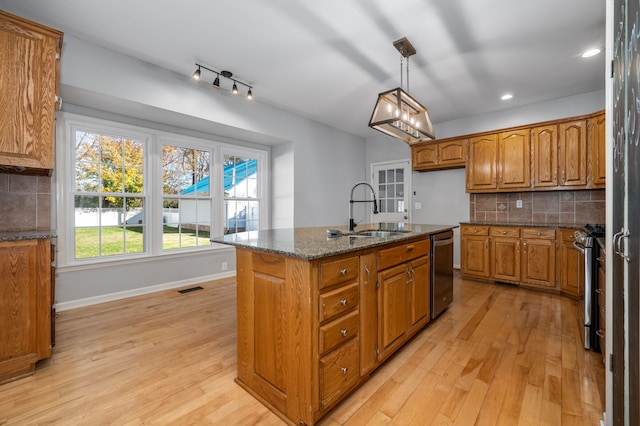 kitchen with a kitchen island with sink, light hardwood / wood-style flooring, stainless steel appliances, and sink