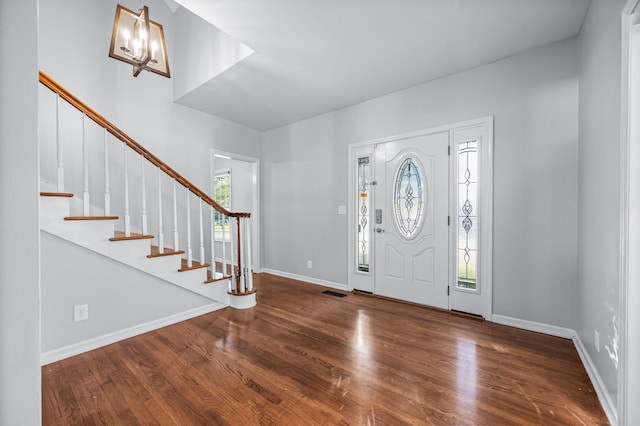 foyer featuring dark wood-type flooring and an inviting chandelier