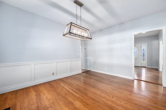 unfurnished dining area featuring light wood-type flooring