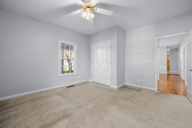 unfurnished bedroom with light carpet, a closet, and ceiling fan