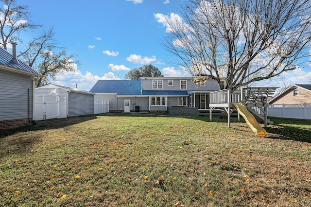 back of property with a playground, a sunroom, and a yard