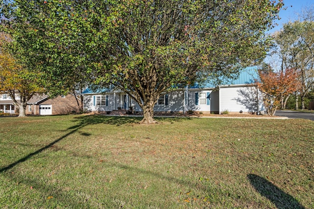 view of property hidden behind natural elements featuring a front lawn