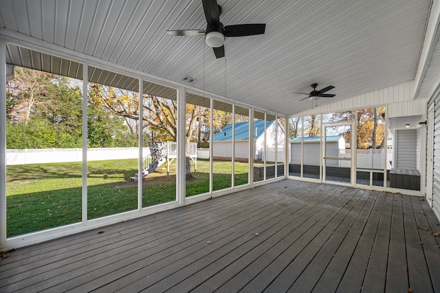 unfurnished sunroom featuring vaulted ceiling, ceiling fan, and a healthy amount of sunlight