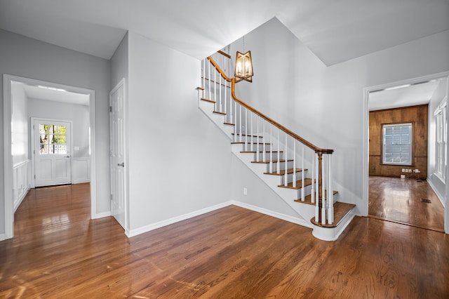 stairs featuring hardwood / wood-style flooring and a notable chandelier