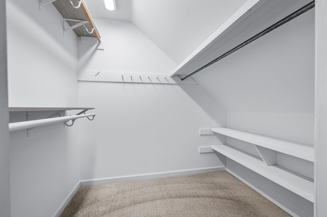 walk in closet featuring carpet flooring and vaulted ceiling