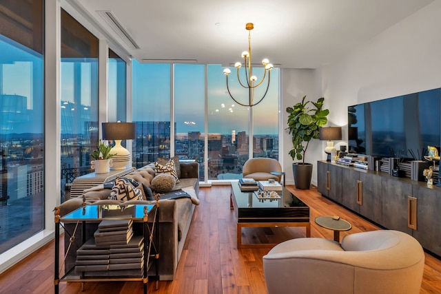 living room with expansive windows, a chandelier, and hardwood / wood-style flooring