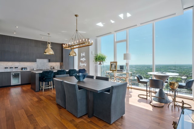 dining room featuring hardwood / wood-style flooring, beverage cooler, and a chandelier