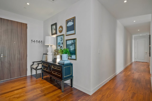 corridor with hardwood / wood-style flooring