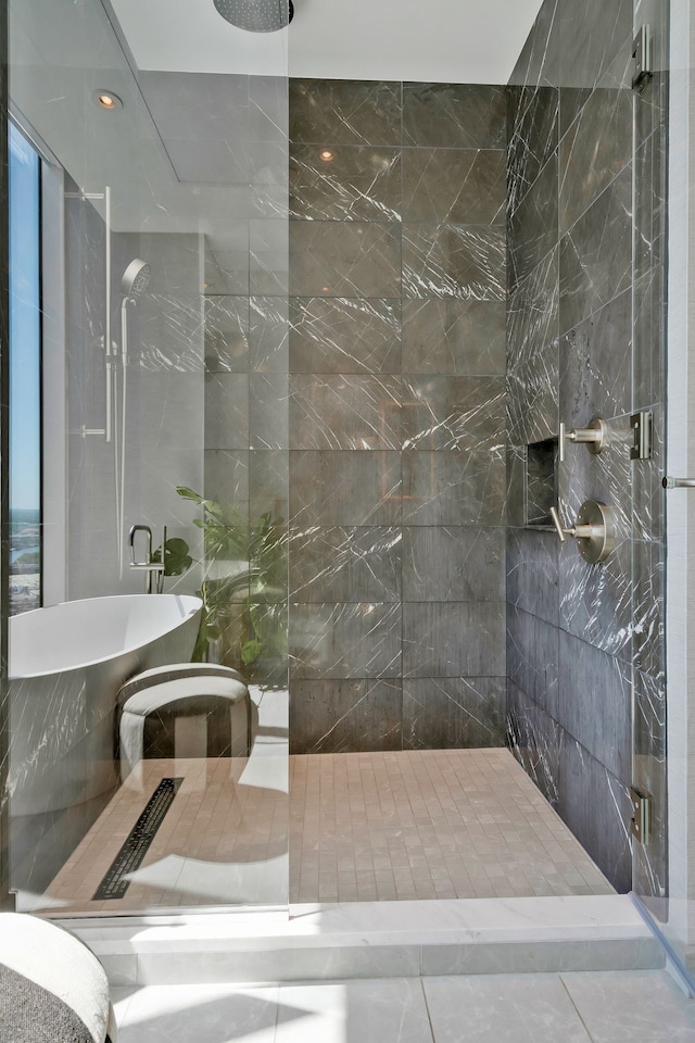 bathroom with tiled shower and tile patterned floors