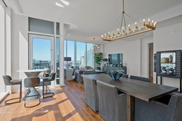 dining space featuring light wood-type flooring and an inviting chandelier