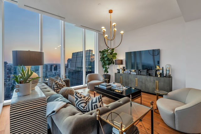 living room featuring hardwood / wood-style flooring, a notable chandelier, a healthy amount of sunlight, and expansive windows