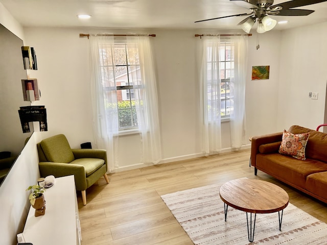 sitting room with ceiling fan and light wood-type flooring