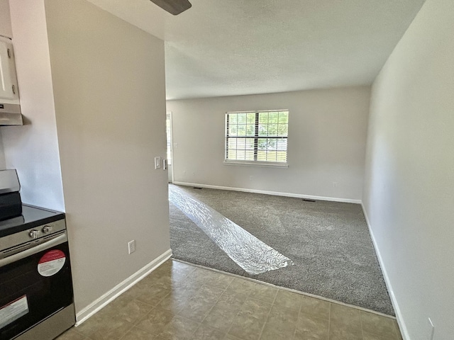 kitchen with stainless steel range, ventilation hood, and light colored carpet