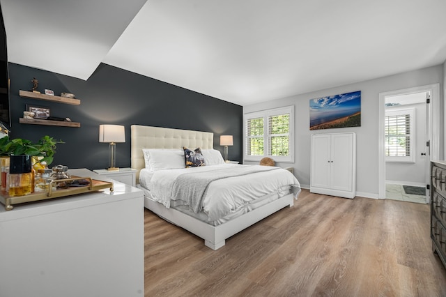 bedroom featuring light hardwood / wood-style flooring and multiple windows