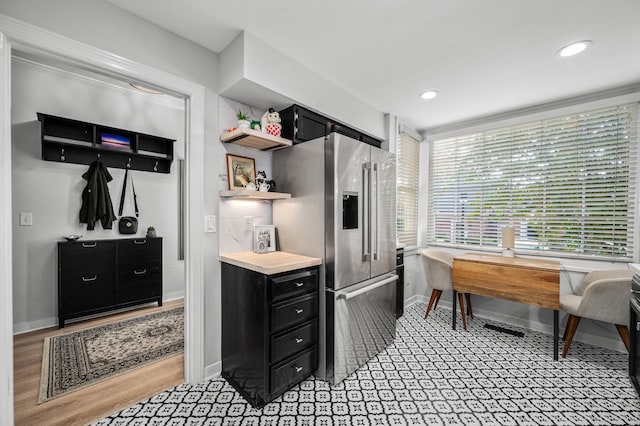 kitchen with high end refrigerator and light hardwood / wood-style floors