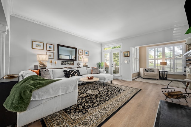 living room featuring wood-type flooring, plenty of natural light, and ornamental molding