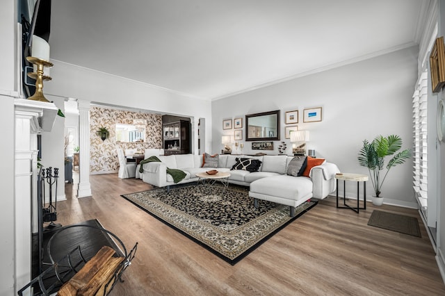 living room featuring ornate columns, crown molding, and hardwood / wood-style floors