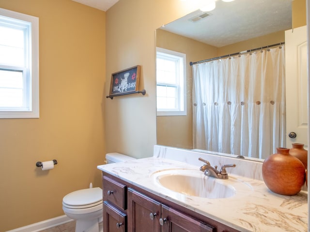 bathroom with a textured ceiling, vanity, and toilet