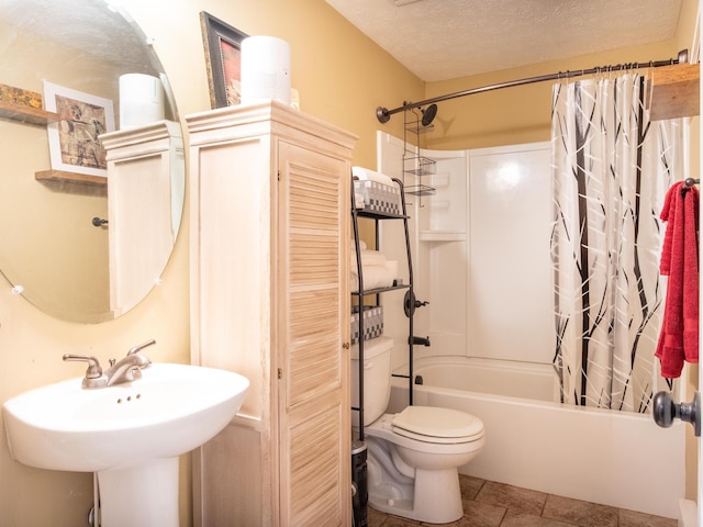 full bathroom featuring shower / tub combo, a textured ceiling, toilet, and sink