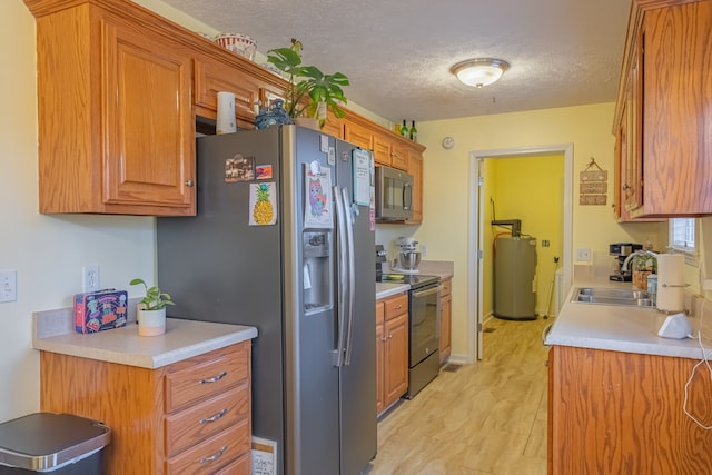 kitchen with a textured ceiling, sink, stainless steel appliances, and water heater