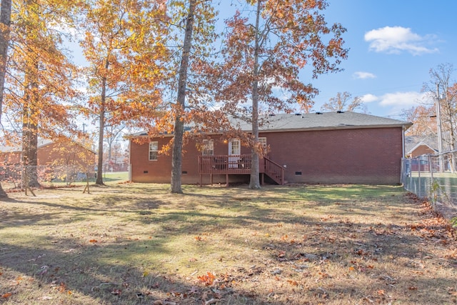 rear view of house with a lawn and a deck