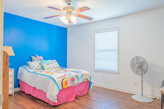 bedroom with ceiling fan and dark wood-type flooring