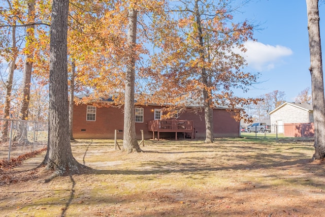 rear view of property featuring a lawn and a wooden deck