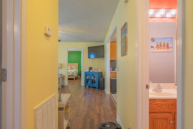 corridor featuring dark hardwood / wood-style floors and sink