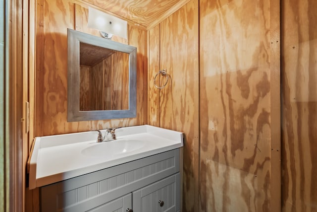 bathroom featuring vanity and wooden walls