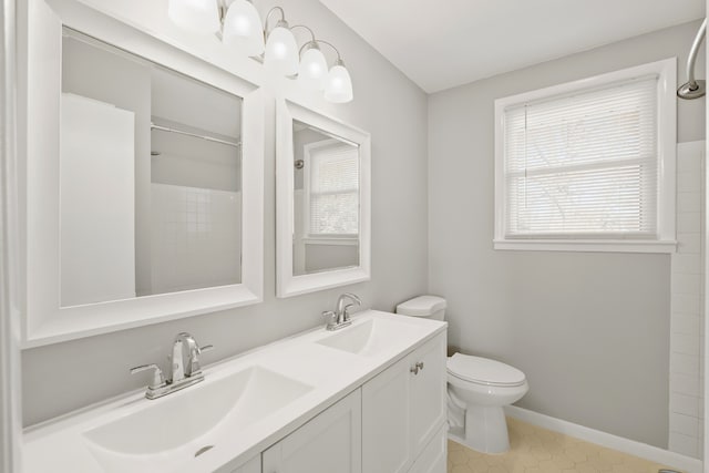 bathroom with vanity, toilet, and a shower