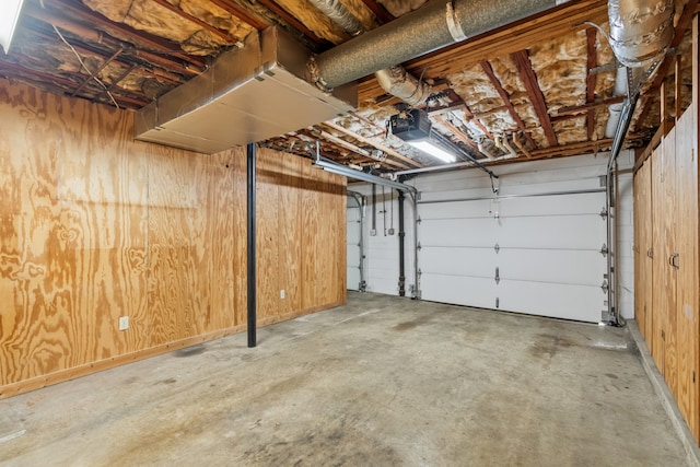 garage featuring a garage door opener and wood walls